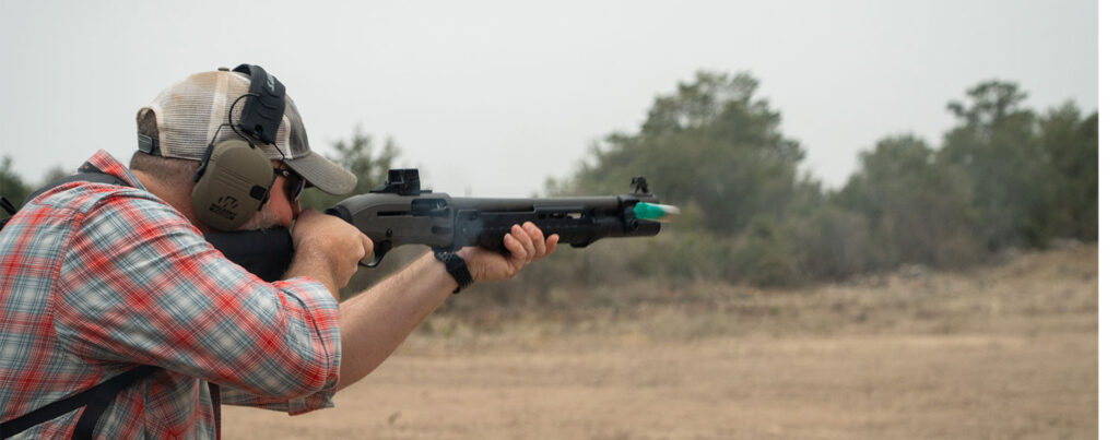 A man fires a shotgun on the range.
